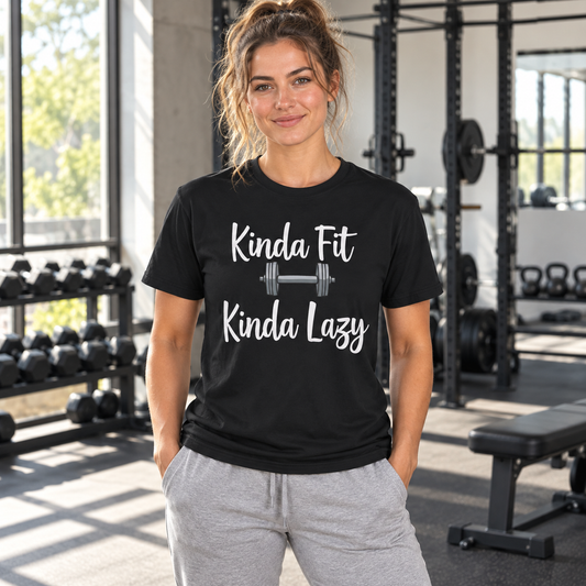 Woman wearing a black Kinda Fit Kinda Lazy graphic T-shirt in a sunlit gym.